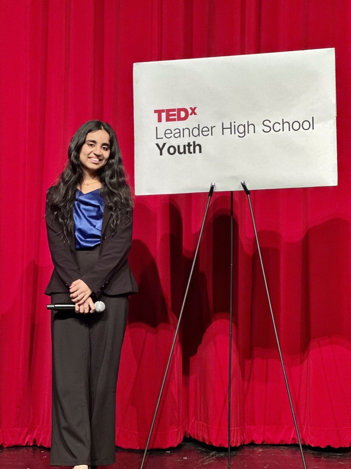Rutu Ruparel beside the TEDx Leander High School Youth sign